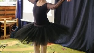 kobieta w czarnej sukience i pozie baletowej